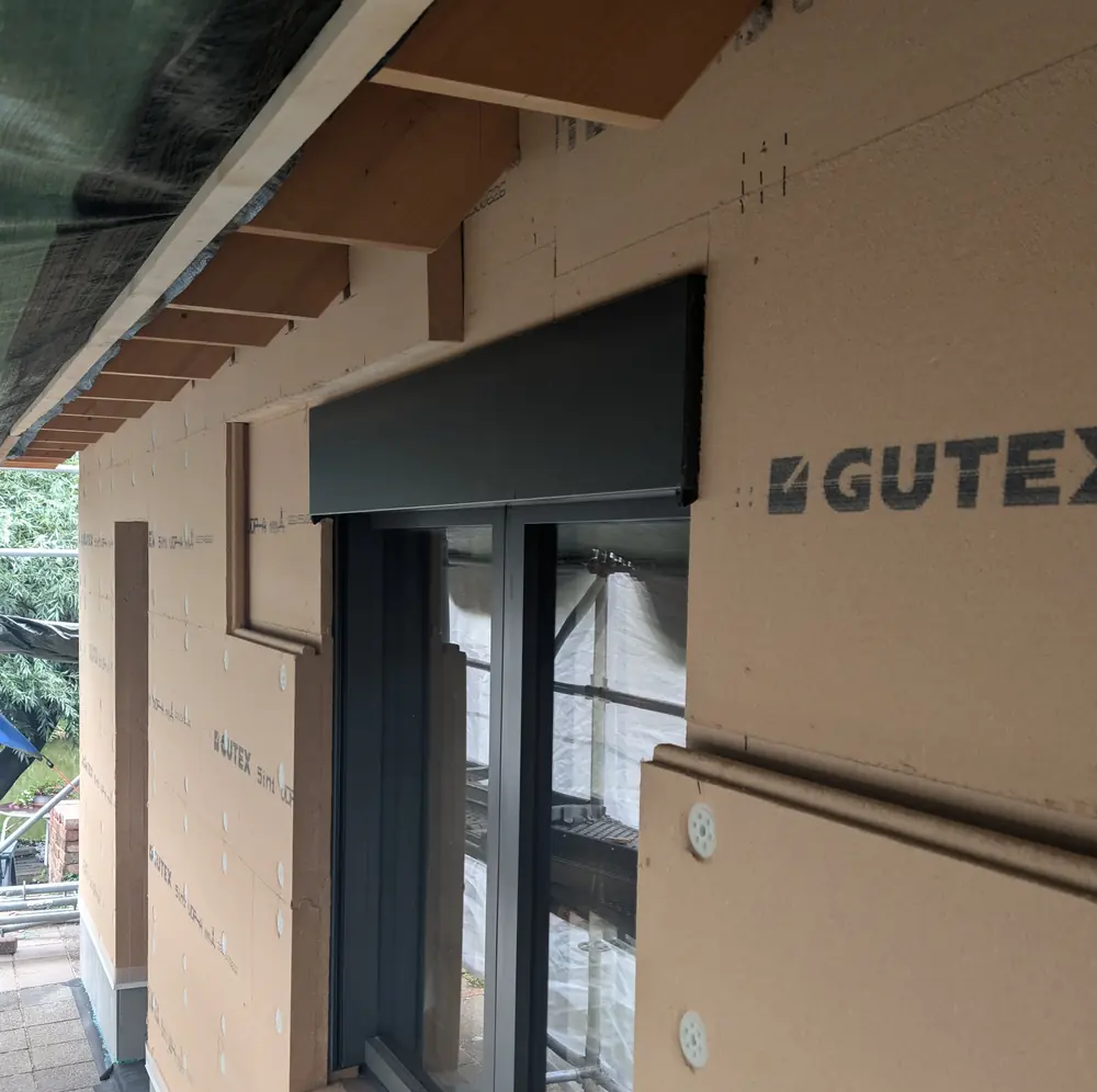 Gevel afgewerkt met houtvezelisolatieplaten rond een kozijn